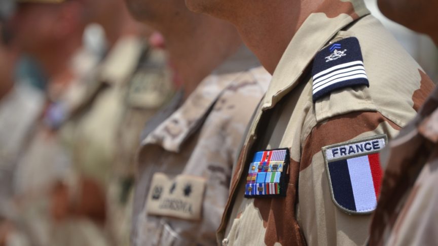 A close up image of a French flag and crest on a soldier's arm