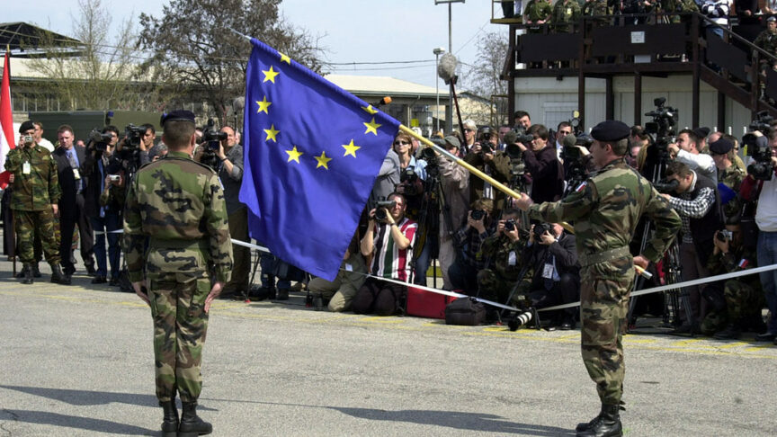 Two soldiers hold a large flag of the EU