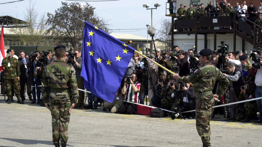 Two soldiers hold a large flag of the EU