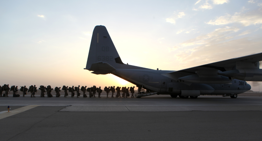 A line of marines boarding a plane after a mission