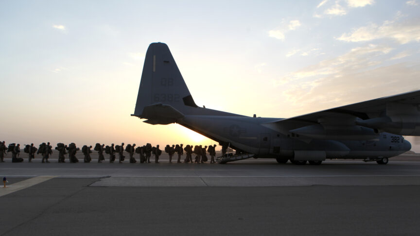 A line of marines boarding a plane after a mission