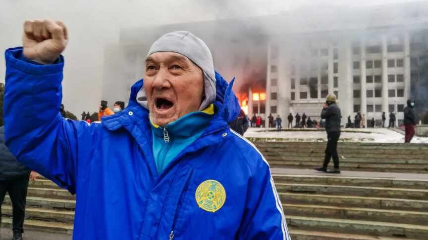 ALMATY, KAZAKHSTAN – JANUARY 5, 2022: A man rallies outside the burning mayors office. Protests are spreading across Kazakhstan over the rising fuel prices; protesters broke into the Almaty mayors office and set it on fire. Yerlan Dzhumayev/TASS