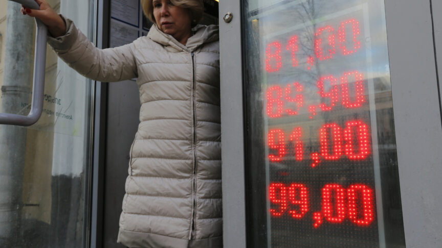 In this Feb. 24, 2022, photo, a woman leaves an exchange office with screen showing the currency exchange rates of U.S. Dollar and Euro to Russian Rubles in Moscow, Russia. The harsh sanctions imposed on Russia and the resulting crash of the ruble have the Kremlin scrambling to keep the country’s economy running. For Russian President Vladimir Putin, that means finding workarounds to the economic blockade even as his forces continue to invade Ukraine. (AP Photo/Alexander Zemlianichenko Jr., File)