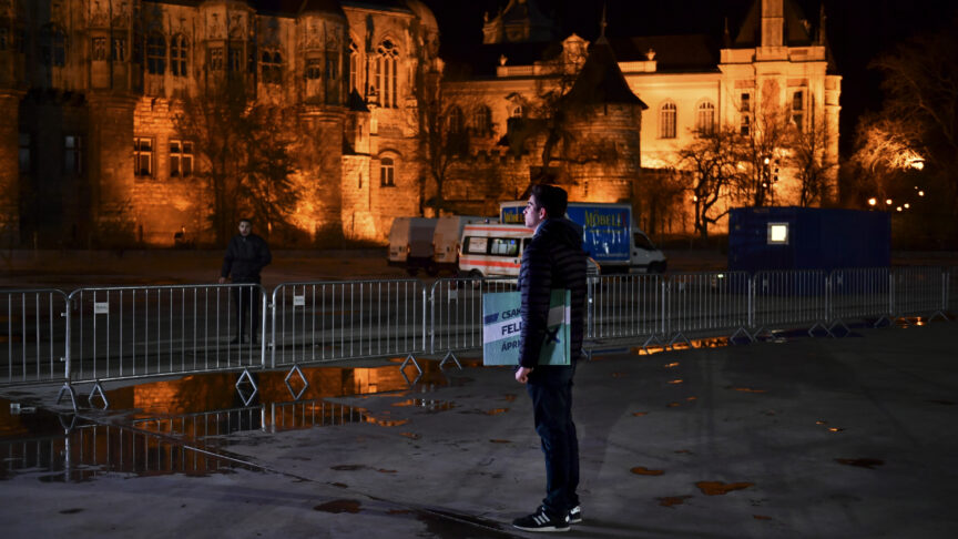 A lone supporter of opposition leader Peter Marki-Zay waits for preliminary results of the general election on a cold night in Budapest, Hungary, Sunday, April 3, 2022. Hungarians voters in the Central European country faced a choice: take a chance on a diverse, Western-looking coalition of opposition parties, or grant nationalist Prime Minister Viktor Orban a fourth consecutive term. (AP Photo/Anna Szilagyi)