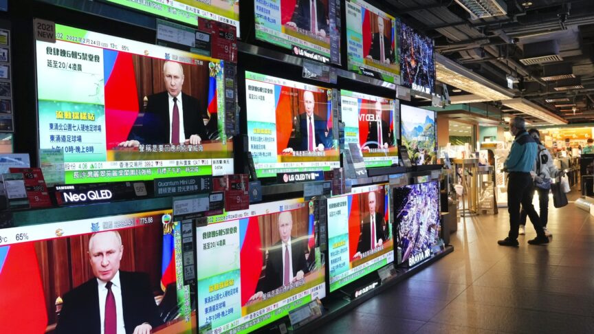 People stand by TV screens broadcasting the news of Russian troops that have launched their attack on Ukraine, in Hong Kong Thursday, Feb. 24, 2022. As Russia intensifies its assault on Ukraine, it is getting a helping hand from China in spreading inflammatory and unsubstantiated claims that the U.S. is financing biological weapons labs in Ukraine. (AP Photo/Vincent Yu, File)