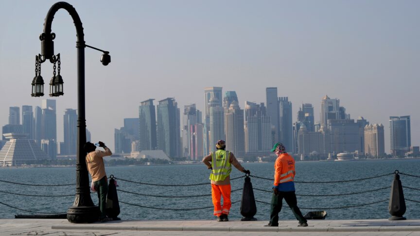 With the city skyline in the background, migrant workers rest at the Doha port, in Doha, Qatar, Sunday, Nov. 13, 2022. Final preparations are being made for the soccer World Cup which starts on Nov. 20 when Qatar face Ecuador. (AP Photo/Hassan Ammar)