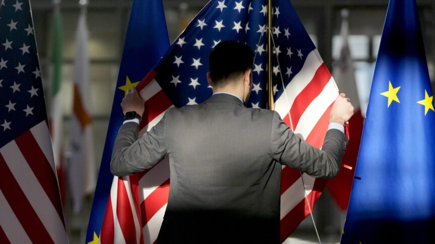 A worker adjusts the US and EU flags prior to the arrival of European Union foreign policy chief Josep Borrell and United States Secretary of State Antony Blinken during the EU-US Energy Council Ministerial meeting at the European Council building in Brussels, Tuesday, April 4, 2023. (AP Photo/Virginia Mayo)