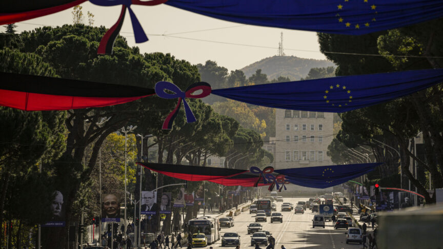 People cross the Martyrs of the Nation boulevard, decorated with Albanian and EU flags as well as portraits of personalities who had a contribution to the advancement of the European Union, in Tirana, Albania, Monday, Dec. 5, 2022. As the war in Ukraine has put the bloc’s enlargement back at the top of the agenda, Albania hosts in Tirana leaders of the EU and the Western Balkans countries for a one-day summit aimed at reinvigorating the bloc’s enlargement process. (AP Photo/Andreea Alexandru)