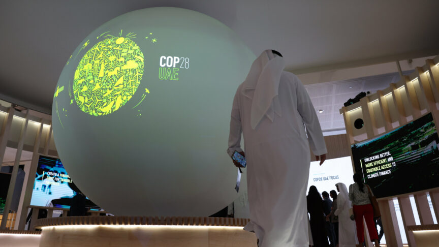 epa10411259 An Emirati walks past the logo of COP 28 UAE during the official launching of COP 28 UAE logo during the World Future Energy Summit 2023 (WFES) in Abu Dhabi, United Arab Emirates, 17 January 2023. The 28th session of the Conference of the Parties (COP28) to the UNFCCC will convene from 30 November to 12 December 2023 in the UAE. Photo: picture alliance/EPA/ALI HAIDER