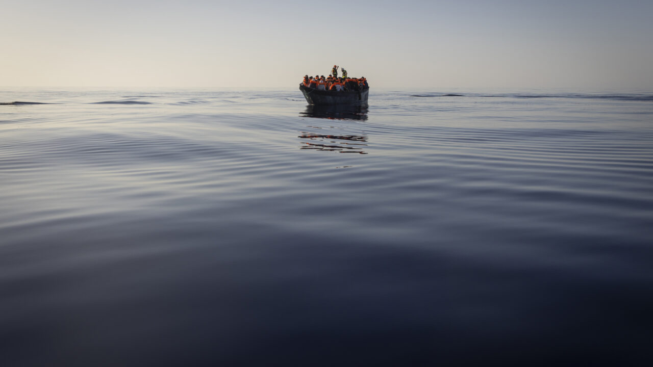 Migrants with life jackets provided by volunteers of the Ocean Viking, a migrant search and rescue ship run by NGOs SOS Mediterranee and the International Federation of Red Cross (IFCR), still sail in a wooden boat as they are being rescued, Aug. 27, 2022, in the Mediterranean sea. The back-to-back shipwrecks of migrant boats off Greece that left at least 22 people dead this week has once again put the spotlight on the dangers of the Mediterranean migration route to Europe
