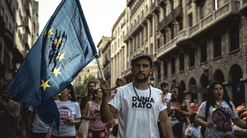 July 13, 2019 – Barcelona, Catalonia, Spain – A human rights activist with a bloodstained EU flag protests over the plight of migrants crossing the Mediterranean