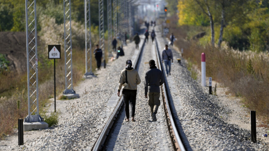 FILE – Migrants walk on the railway tracks near a border line between Serbia and Hungary, at the heart of the so-called Balkan route near village of Horgos, Serbia, Thursday, Oct. 20, 2022. Many of the recent asylum seekers in Austria come from countries like India, Syria, Afghanistan or northern Africa. Often these migrants, who have been trekking up the Balkan route often paying human traffickers thousands of euros, try to reach countries like Germany, Spain or Italy in hopes of finding work there. (AP Photo/Darko Vojinovic, File)