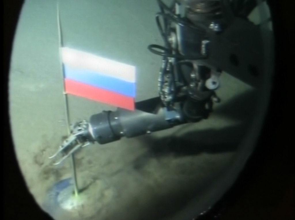 An operator of Russian mini-submarine plants a titanium capsule with the Russian flag during a record dive in the Arctic Ocean under the ice at the North Pole, in this image made from Russian television broadcast on Friday, Aug. 3, 2007.