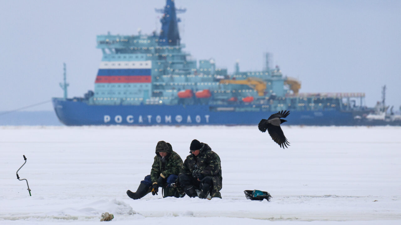 Fishermen fish on the ice of the Gulf of Finland against the backdrop of the nuclear icebreaker Yakutia, which has entered the Gulf of Finland for sea trials in St. Petersburg