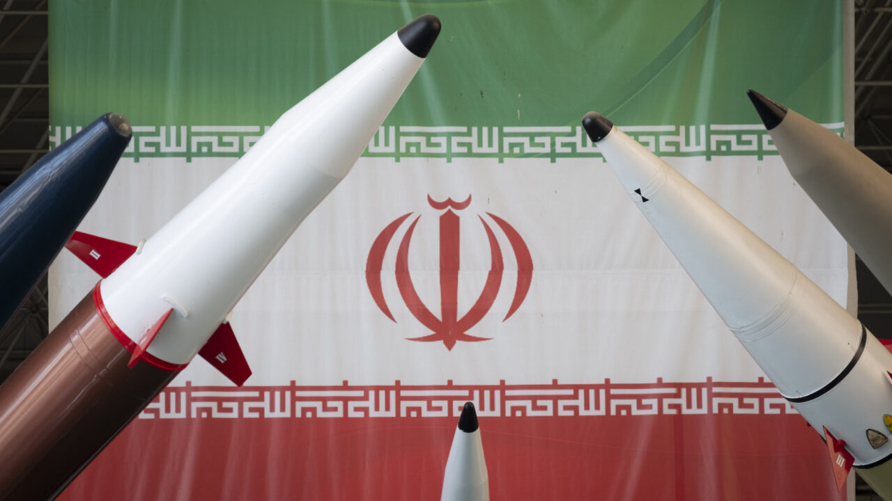 Iranian surface-to-surface missiles are pictured in front of an Iran flag
