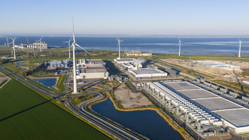 Aerial view of the Google Data Center and wind turbines surrounded by green fields and coastal waters in Eemshaven, Groningen, Netherlands.