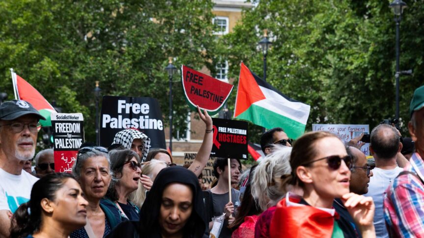 Ein Foto zeigt eine Menschenmenge mit Protestschildern, die in London demonstriert.