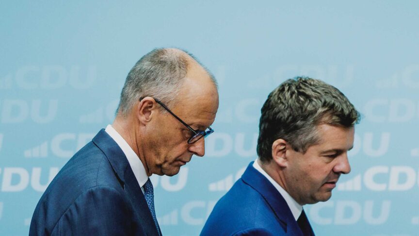 Ein Foto zeigt zwei Männer in Anzügen, nebeneinander stehend, vor hellem Hintergrund mit wiederholtem CDU-Logo.