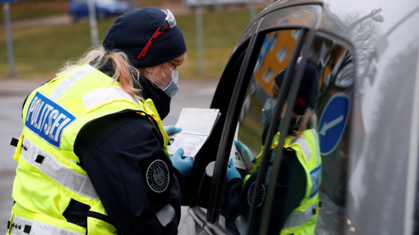 An Estonian police officer checks documents at the border crossing point as Estonia reintroduces border control and a ban to enter Estonia for foreigners as a preventive measure against the coronavirus disease (COVID-19) in Valga, Estonia