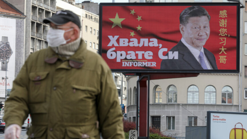 A man wearing a protective mask passes by a billboard depicting Chinese President Xi Jinping as the spread of the coronavirus disease (COVID-19) continues in Belgrade, Serbia, April 1, 2020. The text on the billboard reads “Thanks, brother Xi”.