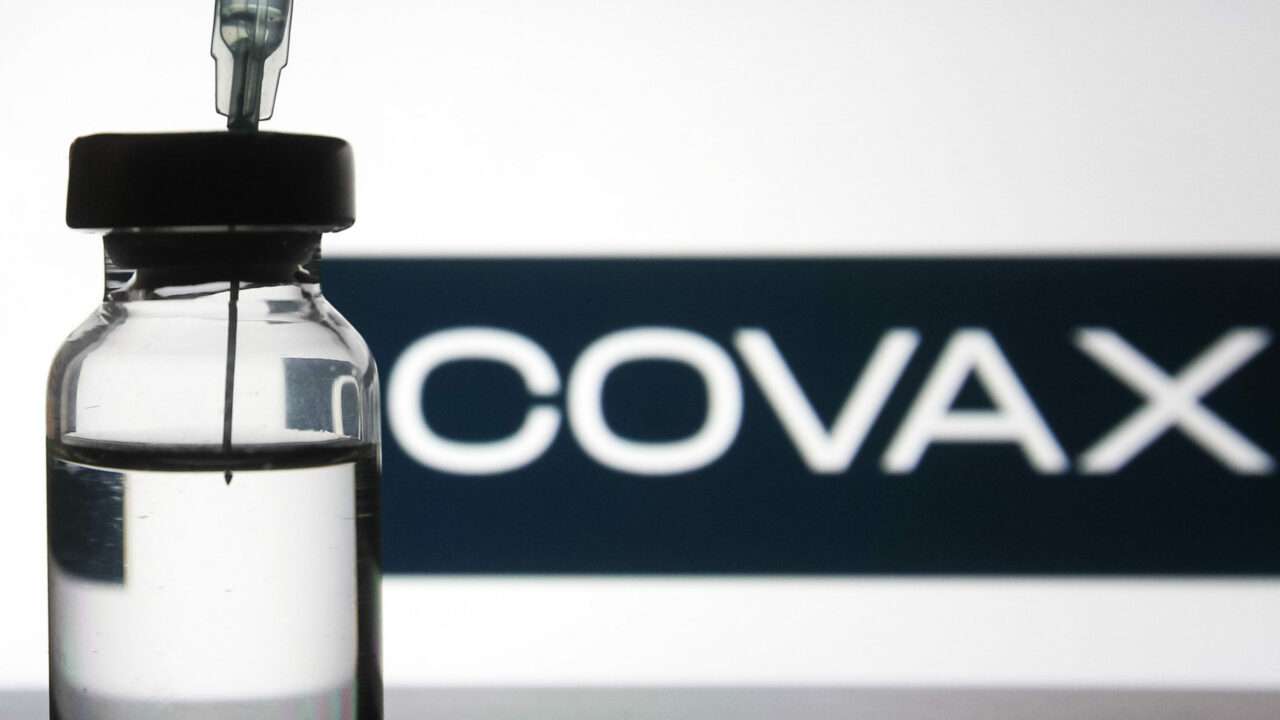 A medical syringe and a vial in front of the COVAX logo. More than 150 COVID-19 coronavirus vaccines are in development across the world, several of which have reached the third phase of clinical trials, as reported in the media
