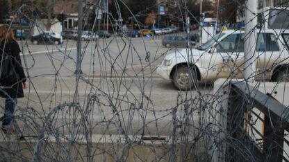 Barbed wire in front of a police car in North Mitrovica