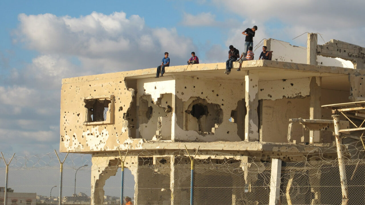 Children sit on top of a destroyed building in Gaza